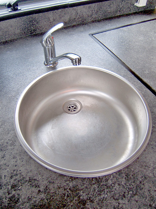 The stainless steel sink with single swan neck mixer tap.